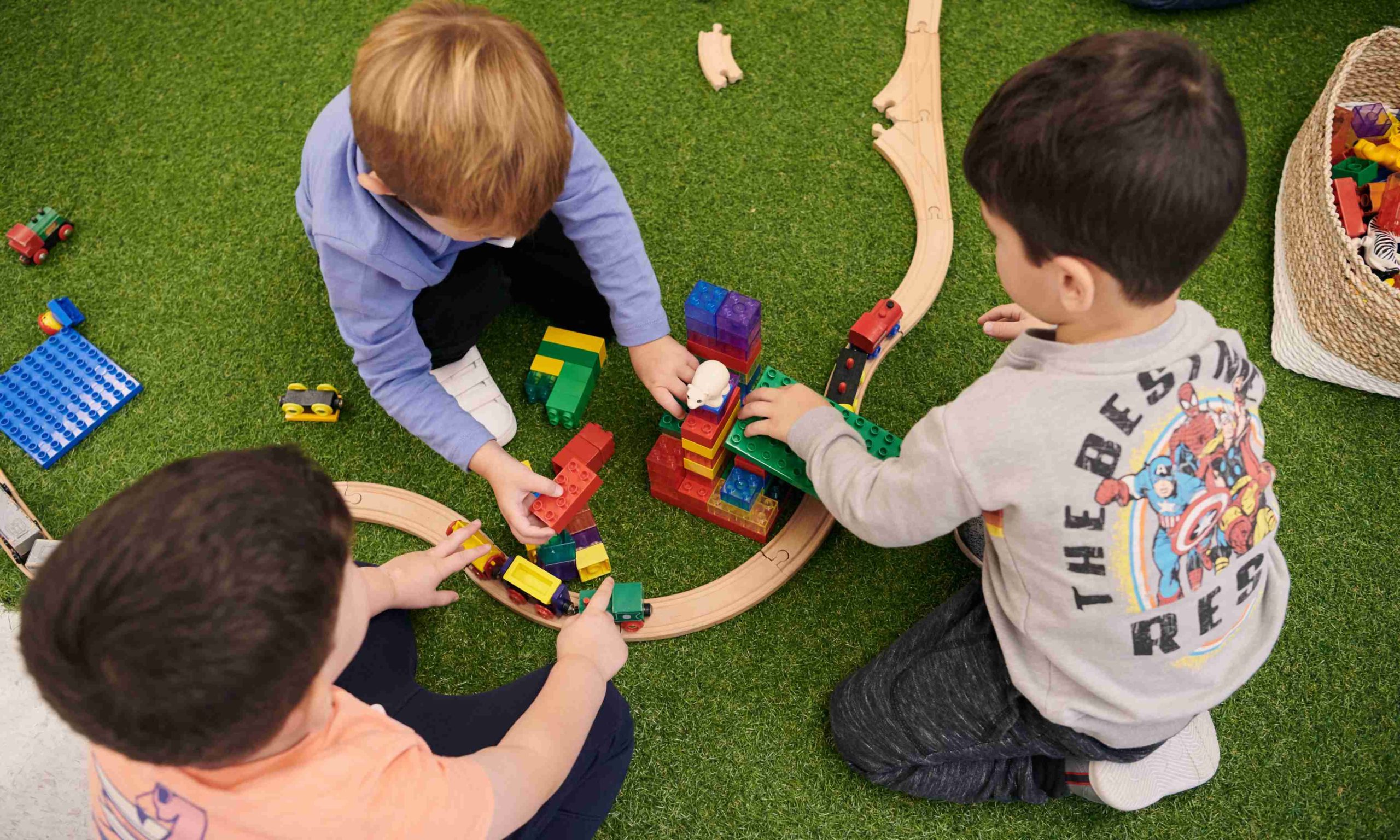 Three boys playing with a train set